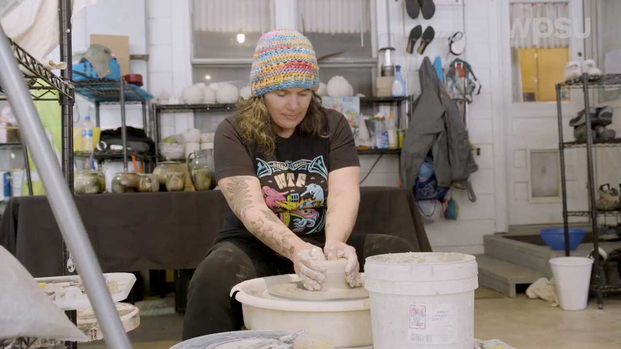 artist working clay on pottery wheel