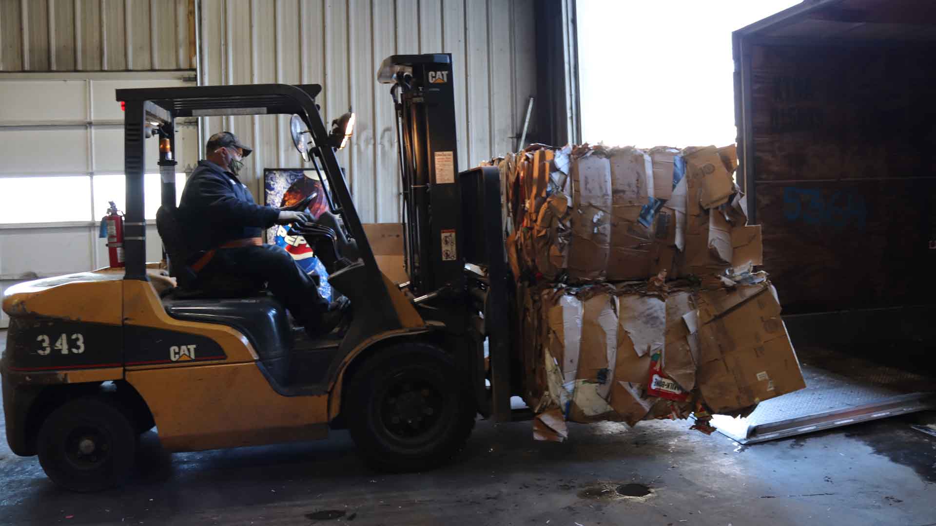 cardboard bales being loaded onto a truck