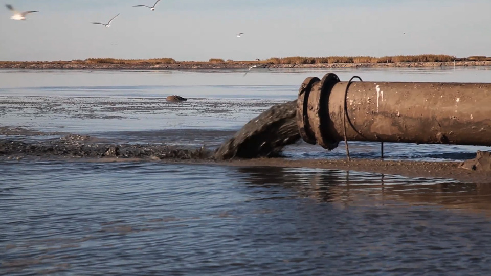 pipe discharging mud into Louisiana wetlands