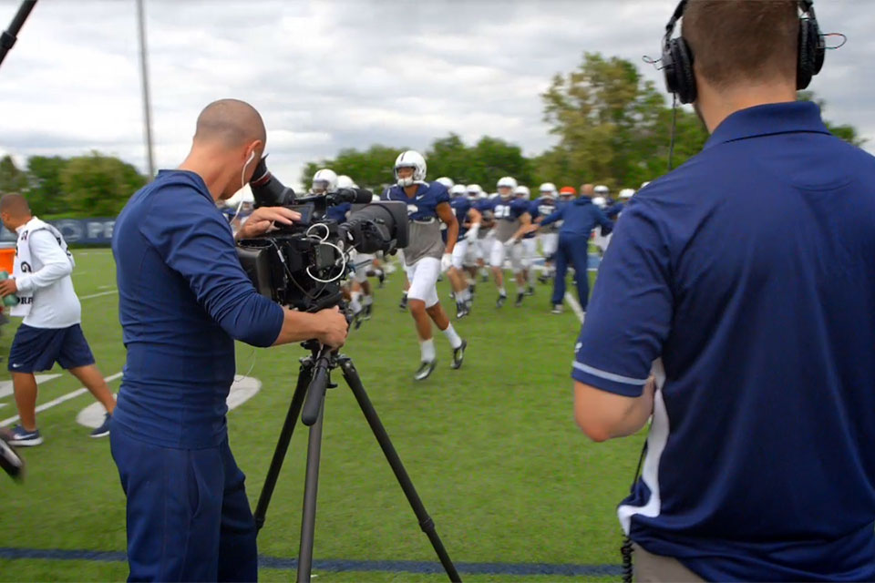 Cameraman filming Penn State football practice