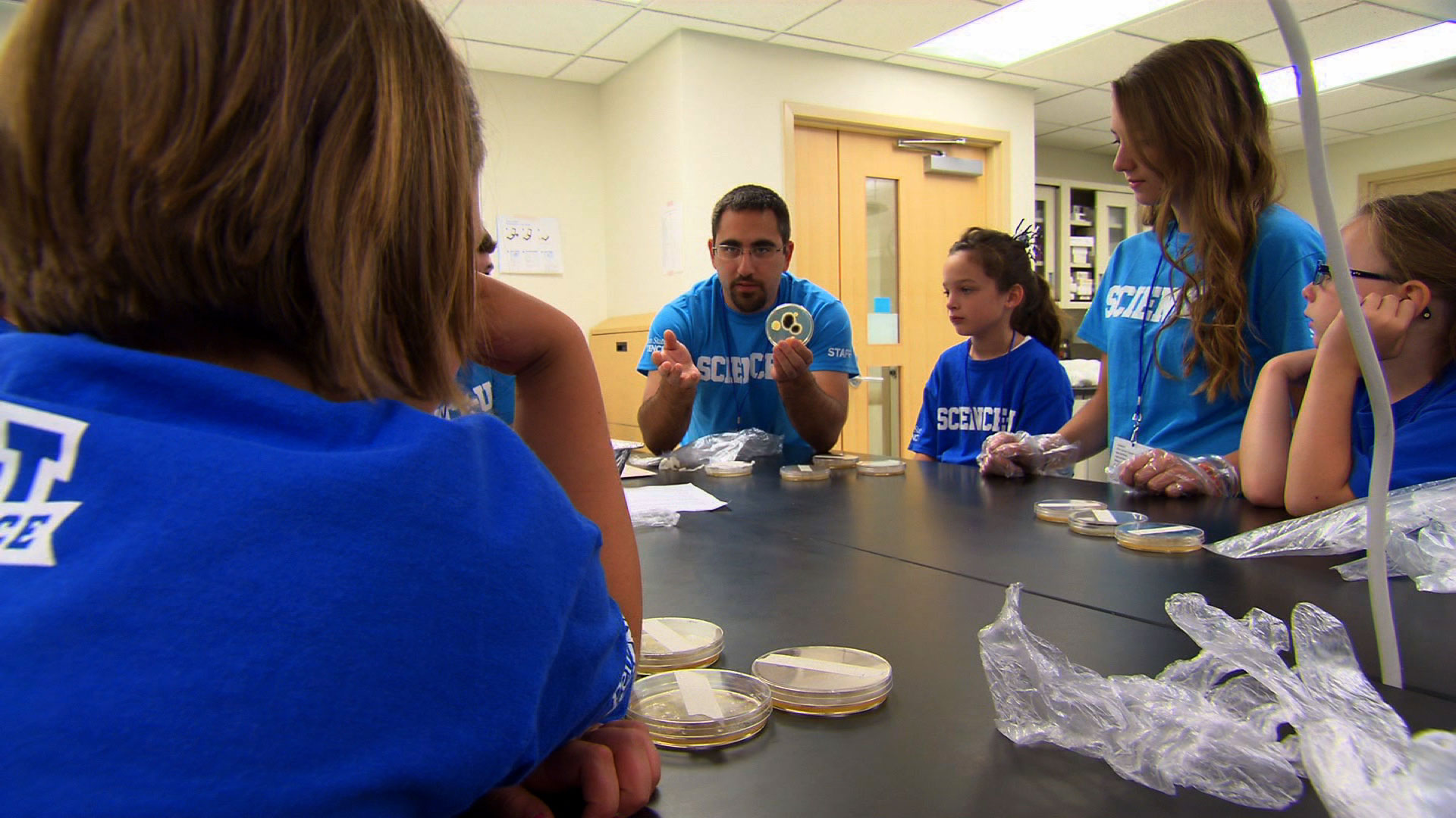 Instructor shows students petri dish