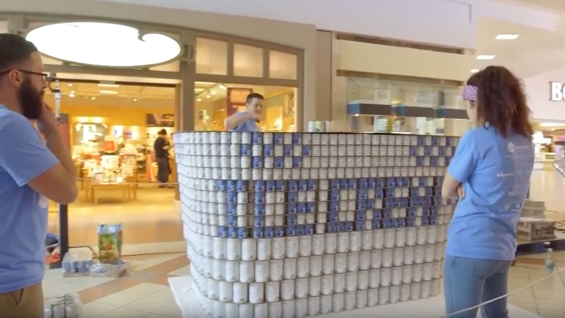 People building structure out of canned food.