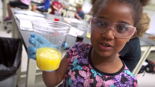 young girl holding a cup of orange juice