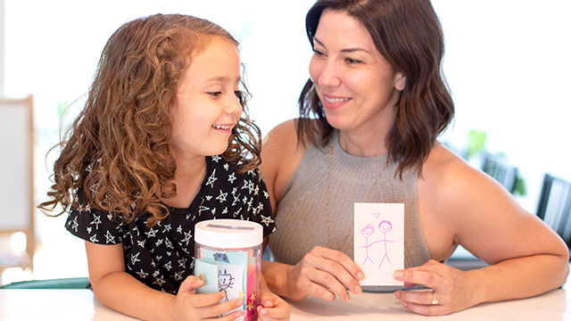 parent and child holding jars