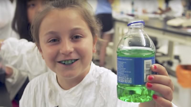 girl holding a bottle with green liquid