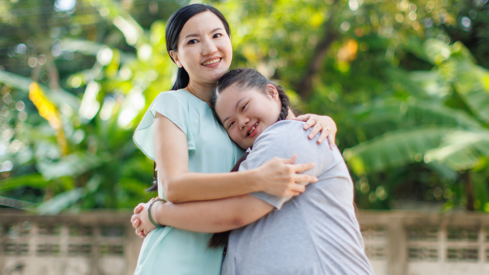 woman and teen hugging outside