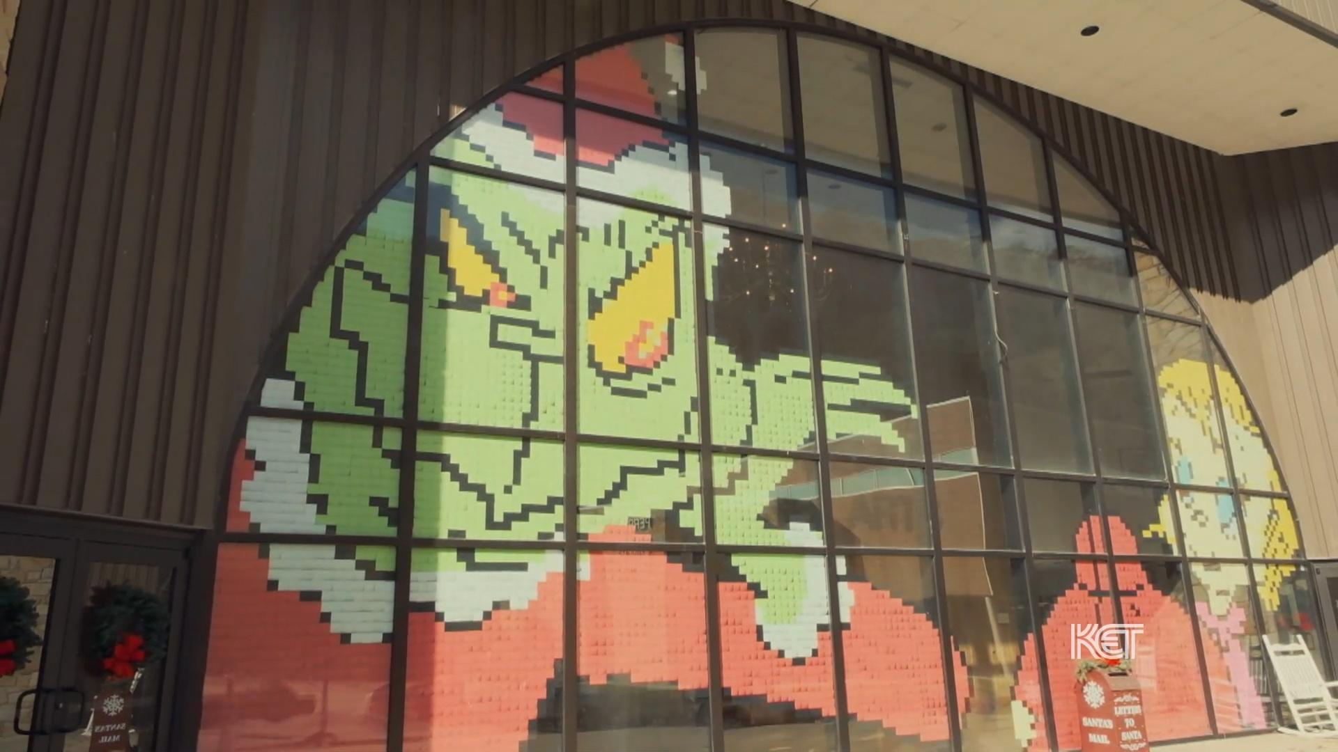 A window display of the Grinch out of post-it notes.