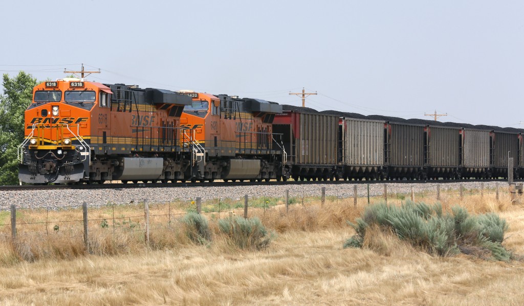 Two train engines pulling several containers.