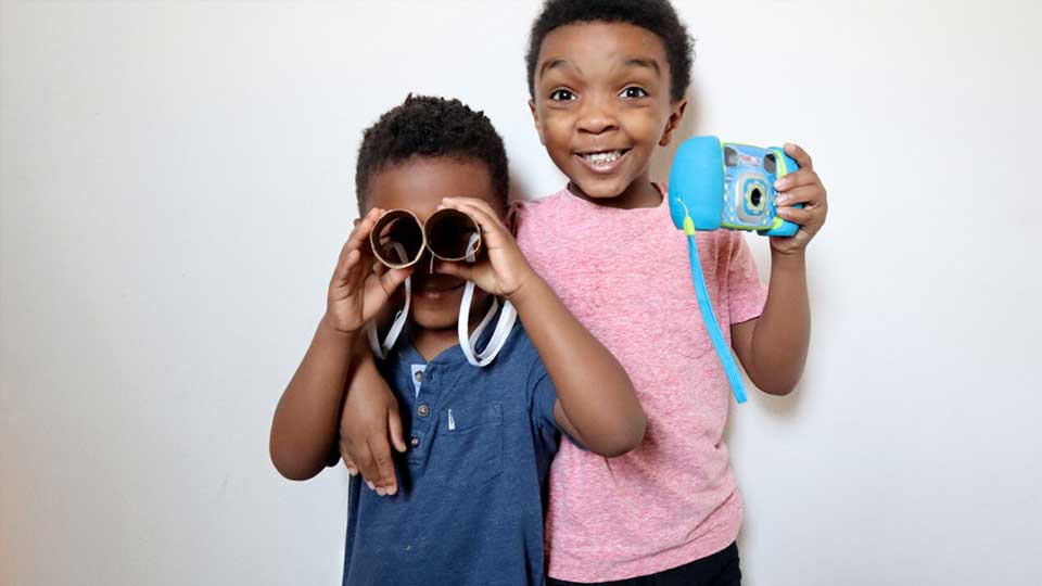 young kids playing with a camera