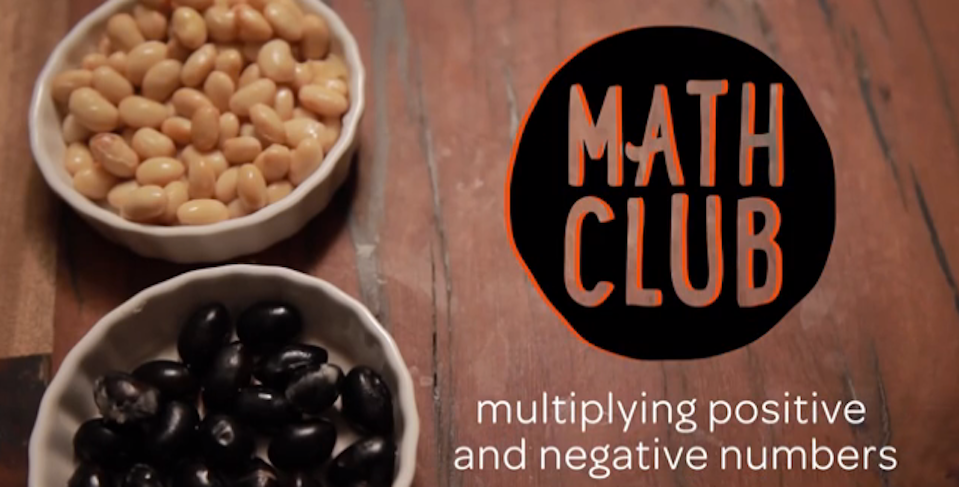 Two bowls of beans behind the words "Math Club" and "multiplying positive and negative numbers".