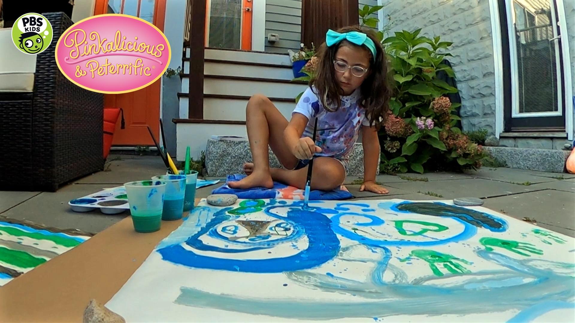 A girl painting on the ground.