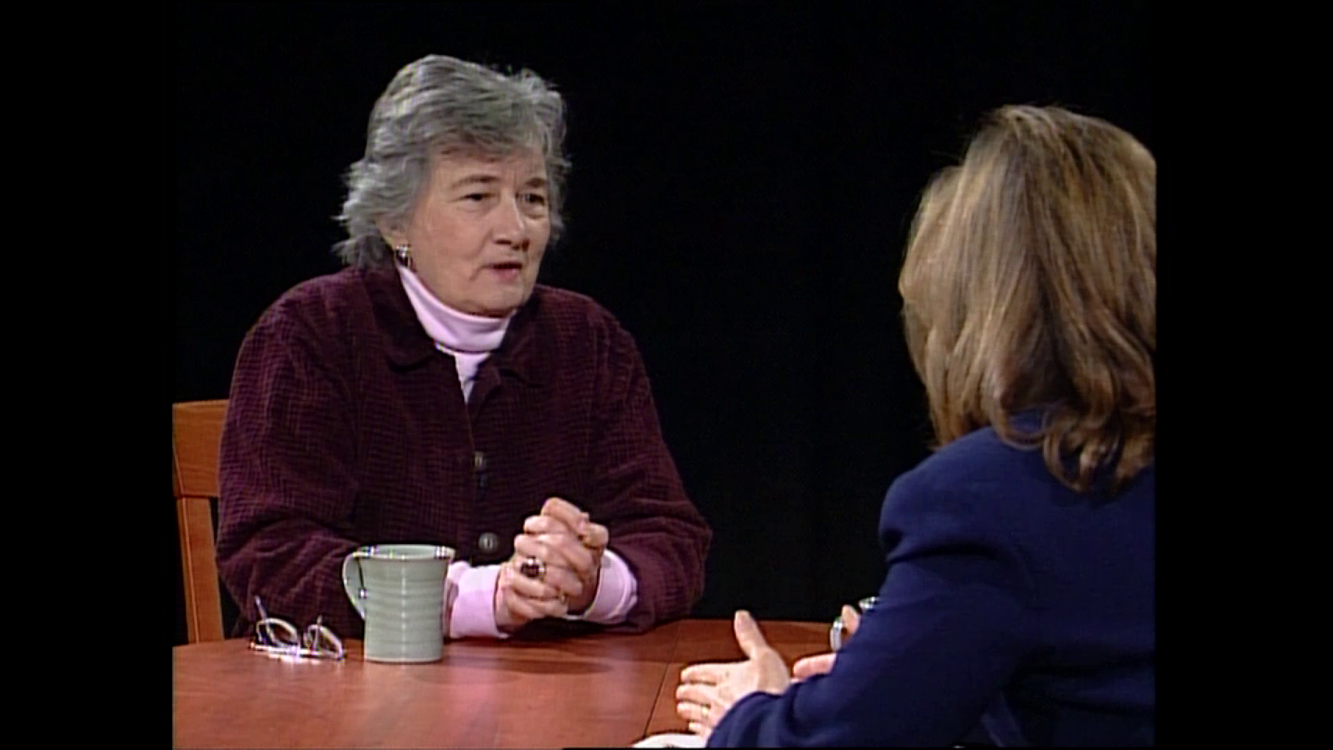 Katherine Paterson, a white woman, sitting across the table from an interviewer.