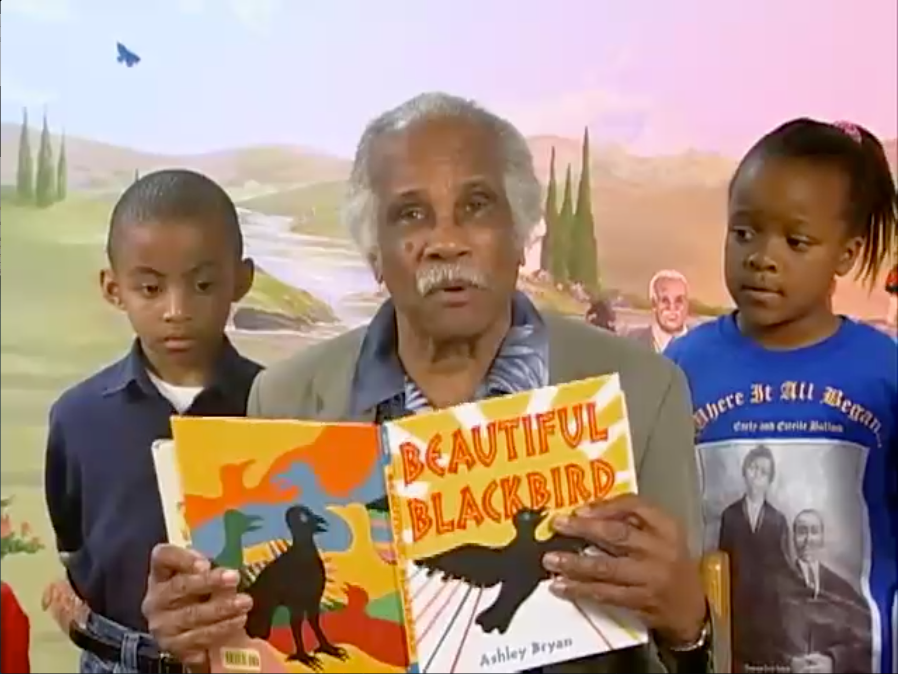 A man with two children reading a book.