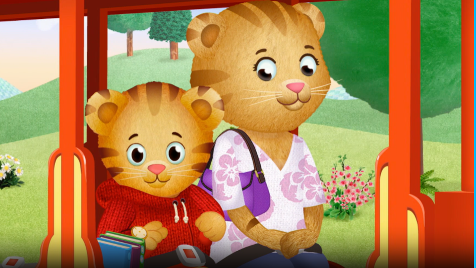 A cartoon tiger child and his mother sit on a red trolley.