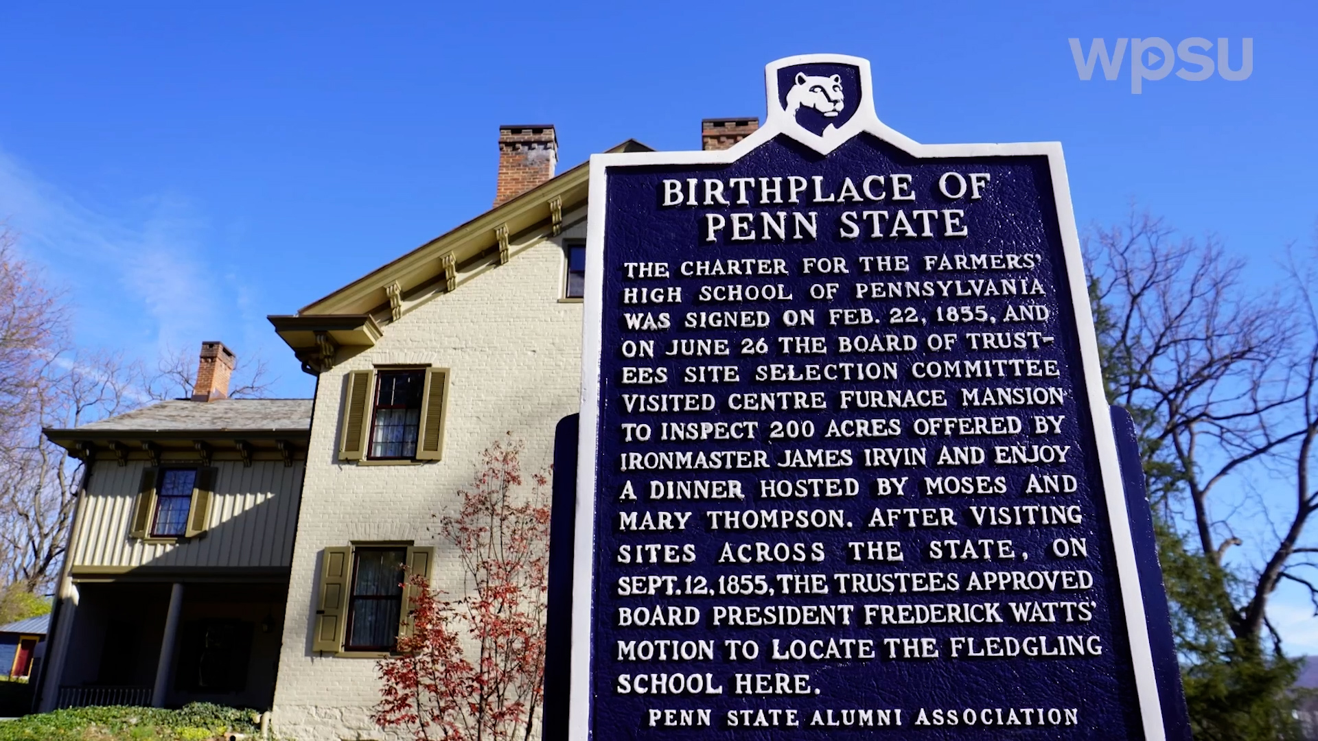 A blue historical describing the founding of Penn State in front of the Centre Furnace Mansion.