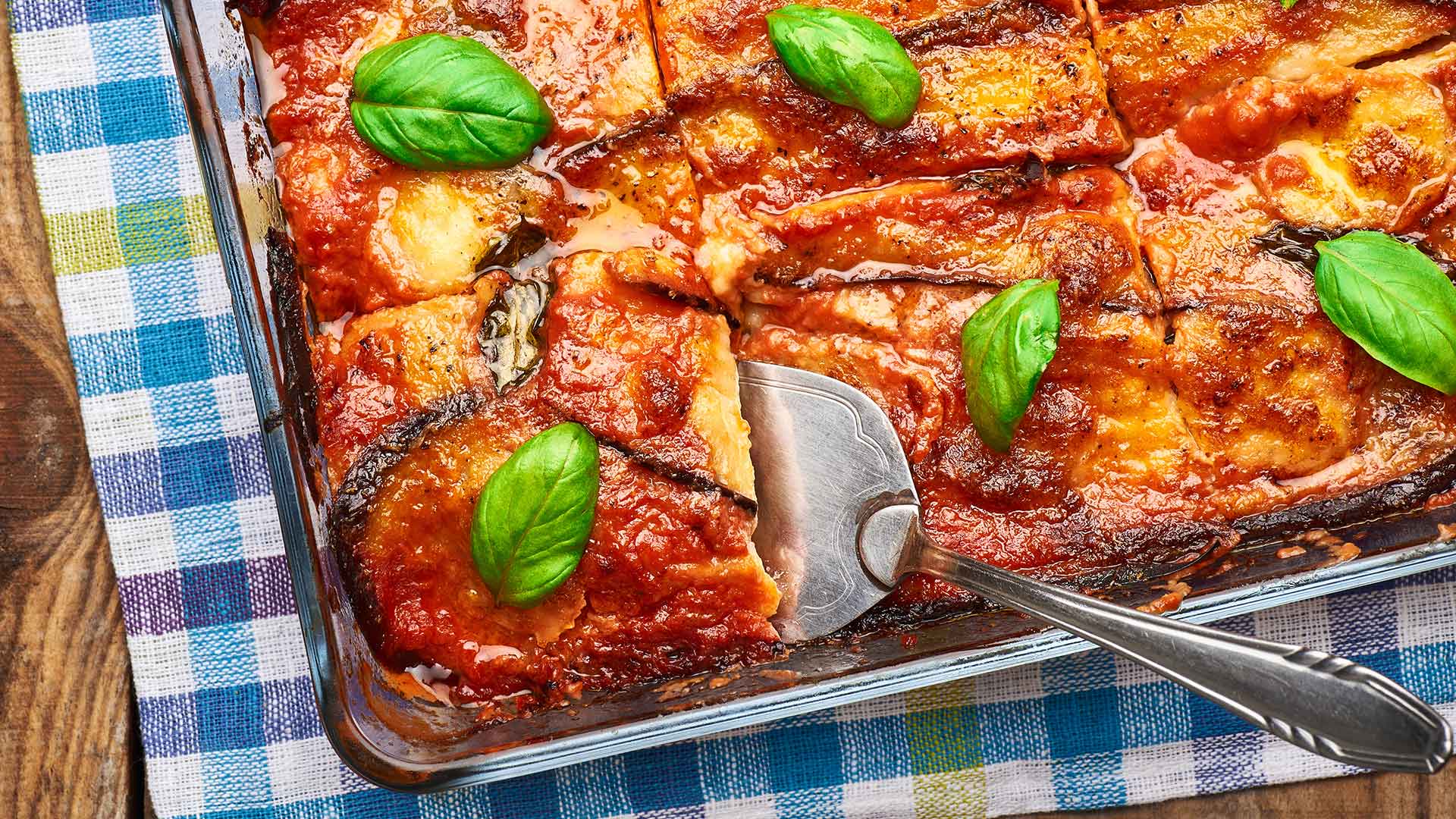 Tray of eggplant parmesan with serving spoon