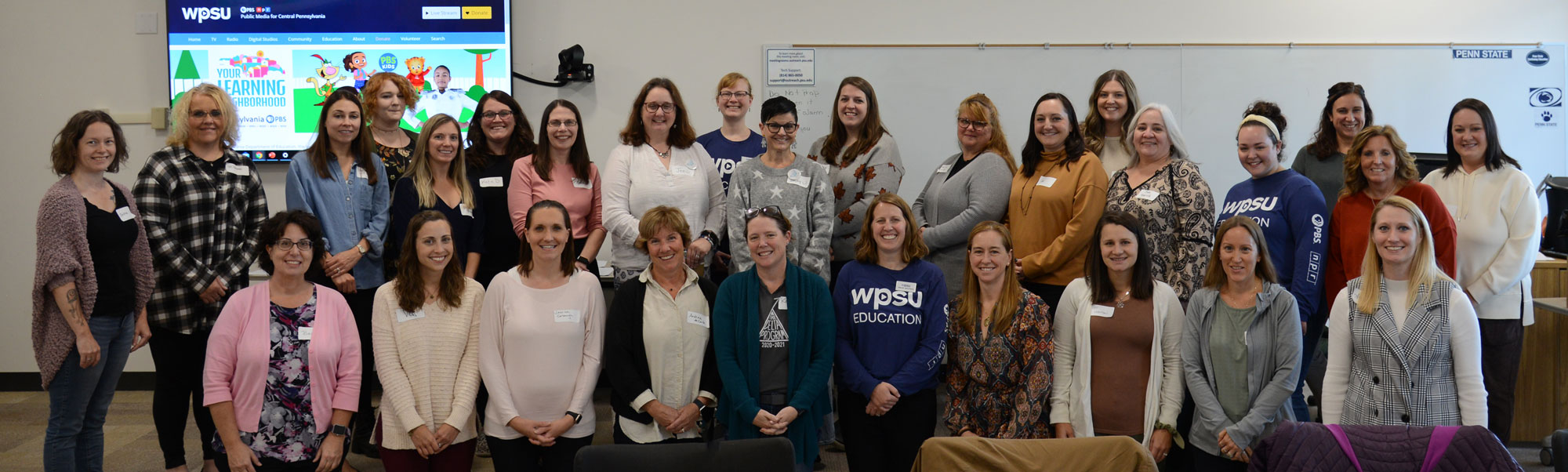 Group of 29 women standing in a classroom.