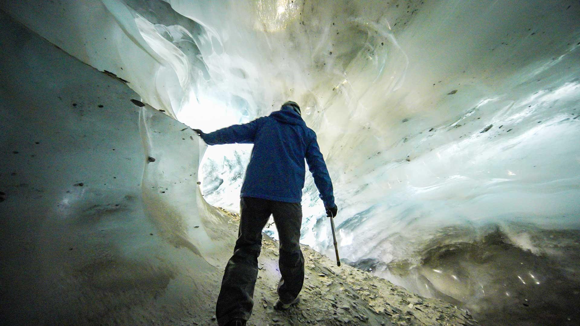 person looking in ice cave. 