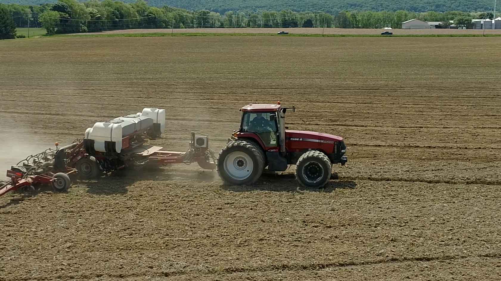 Tractor harvesting crops in a large field.