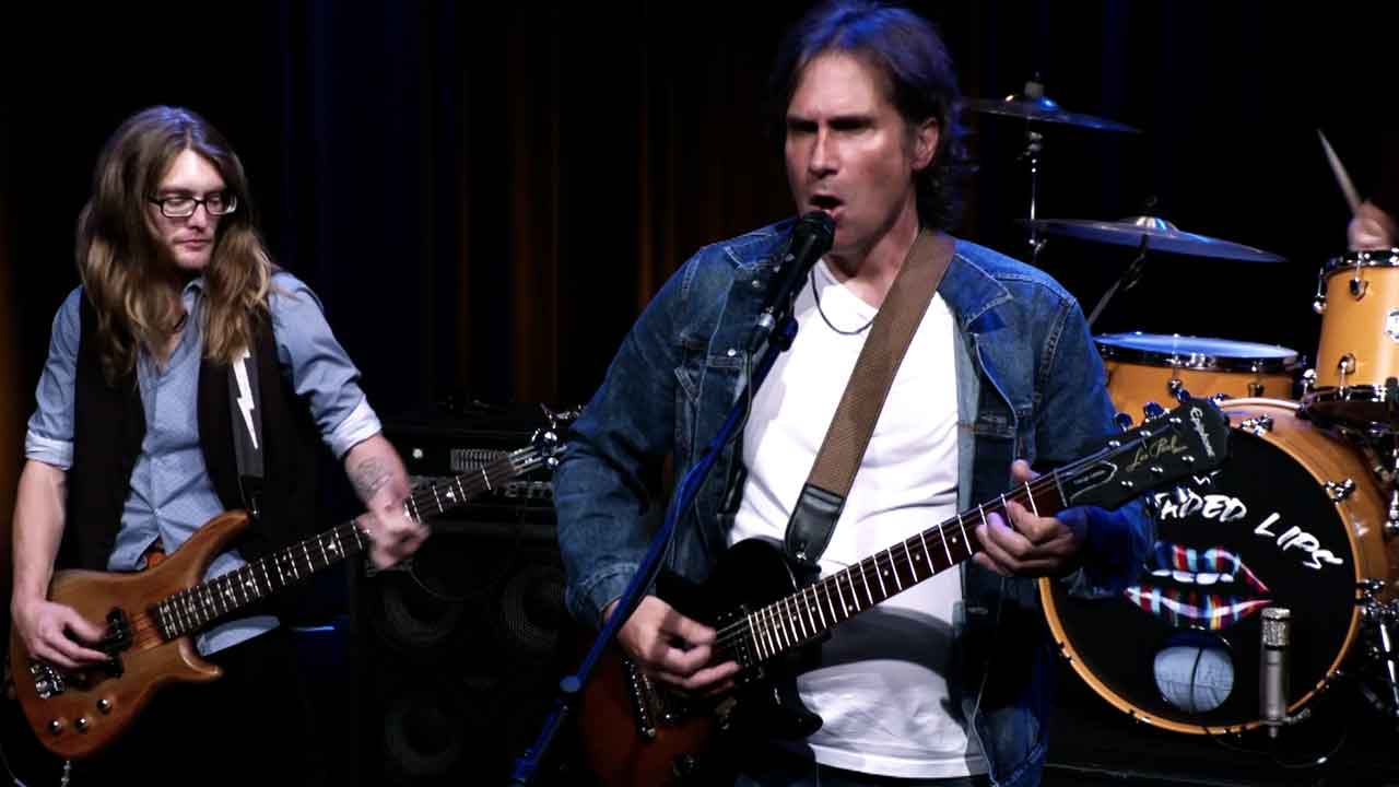 Two men playing guitars.