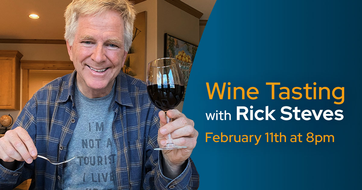 Rick Steves holding a glass of red wine.