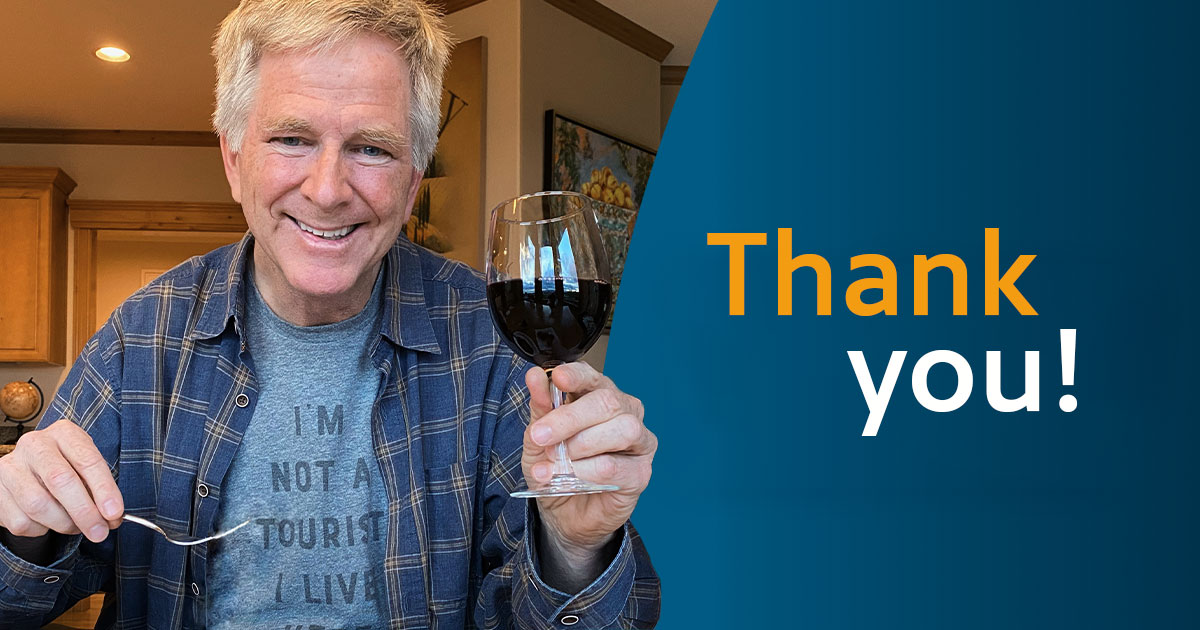 Rick Steves holding a glass of red wine.
