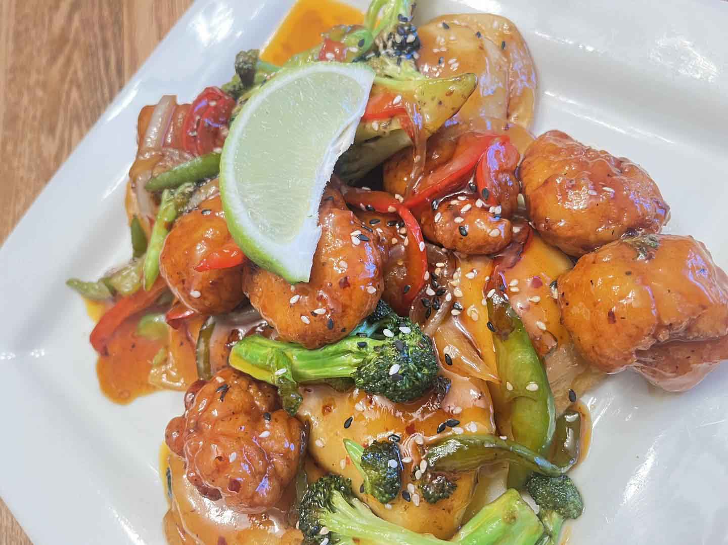 fried chicken pieces mix with veggies and topped with lime wedge