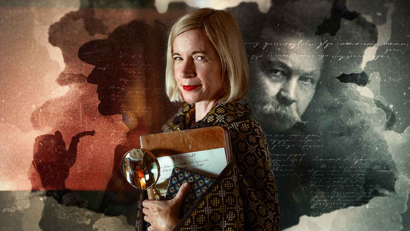 Lucy Worsley holding a folder of documents and a magnifying glass.